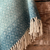 Tirkīzzila toņa īsais/pusgarais aitas vilnas pončo ar baltām bārkstīm