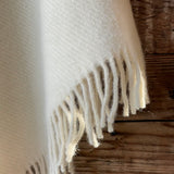 Krēmīgi balts 100% vilnas pončo ar kapuci un bārkstīm, pusgarais pončo