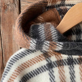 Klasiskas rūtis karameļi brūnos/pelēkos/baltos toņos indiāņu piegriezuma garais aitas vilnas pončo ar kapuci un bārkstīm