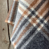 Klasiskas rūtis karameļi brūnos/pelēkos/baltos toņos indiāņu piegriezuma garais aitas vilnas pončo ar kapuci un bārkstīm