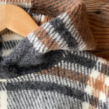 Klasiskas rūtis karameļi brūnos/pelēkos/baltos toņos indiāņu piegriezuma garais aitas vilnas pončo ar kapuci un bārkstīm