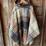 Klasiskas rūtis karameļi brūnos/pelēkos/baltos toņos indiāņu piegriezuma garais aitas vilnas pončo ar kapuci un bārkstīm