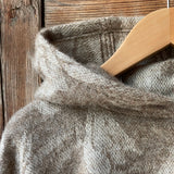 Dūmakaini brūna toņa indiāņu piegriezuma garais mohēras/alpakas/aitas vilnas pončo ar kapuci un bārkstīm ar plezniņu dizainu